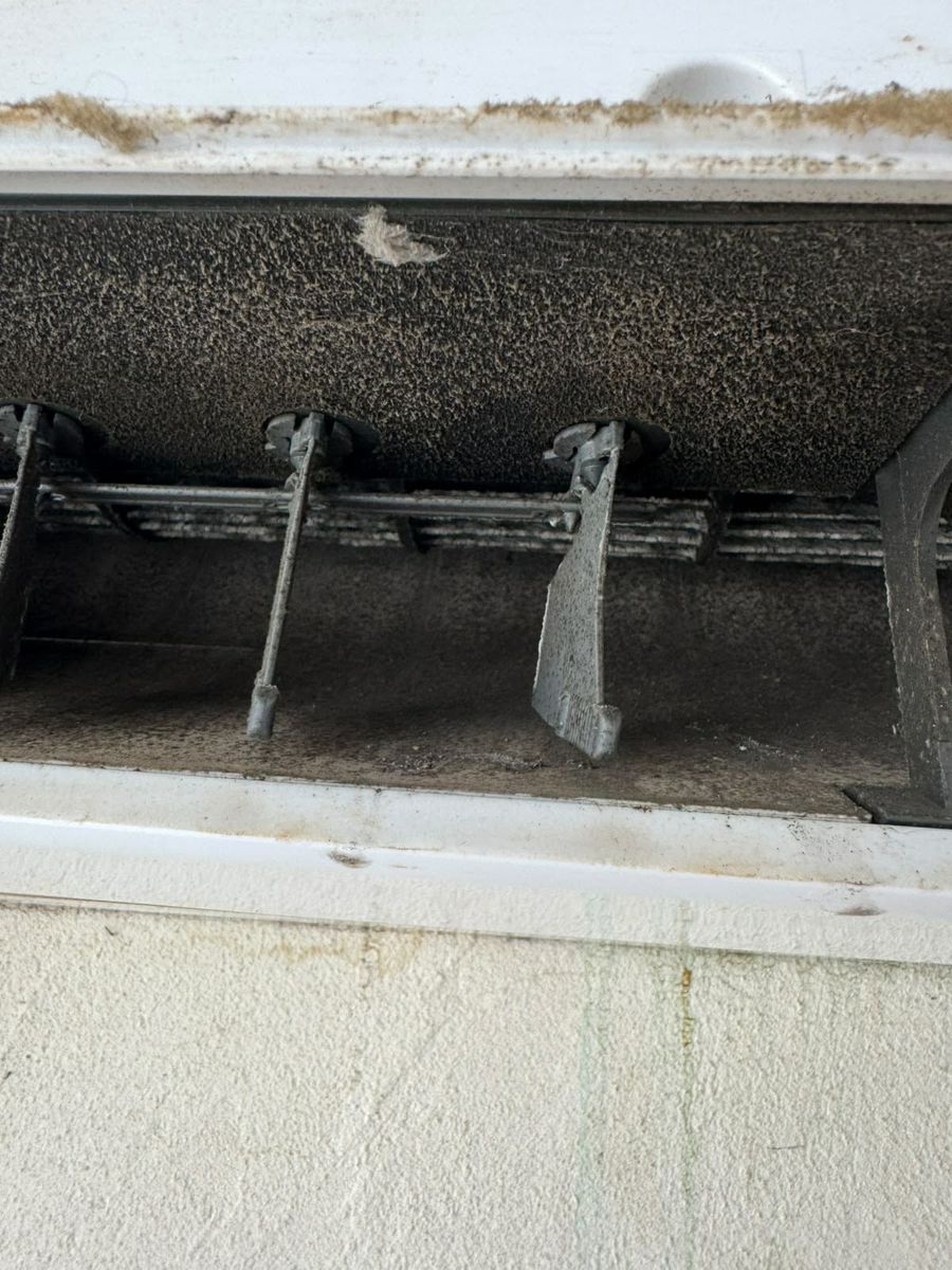 Volets et turbine d'une climatisation murale noircis par la moisissure, avant nettoyage